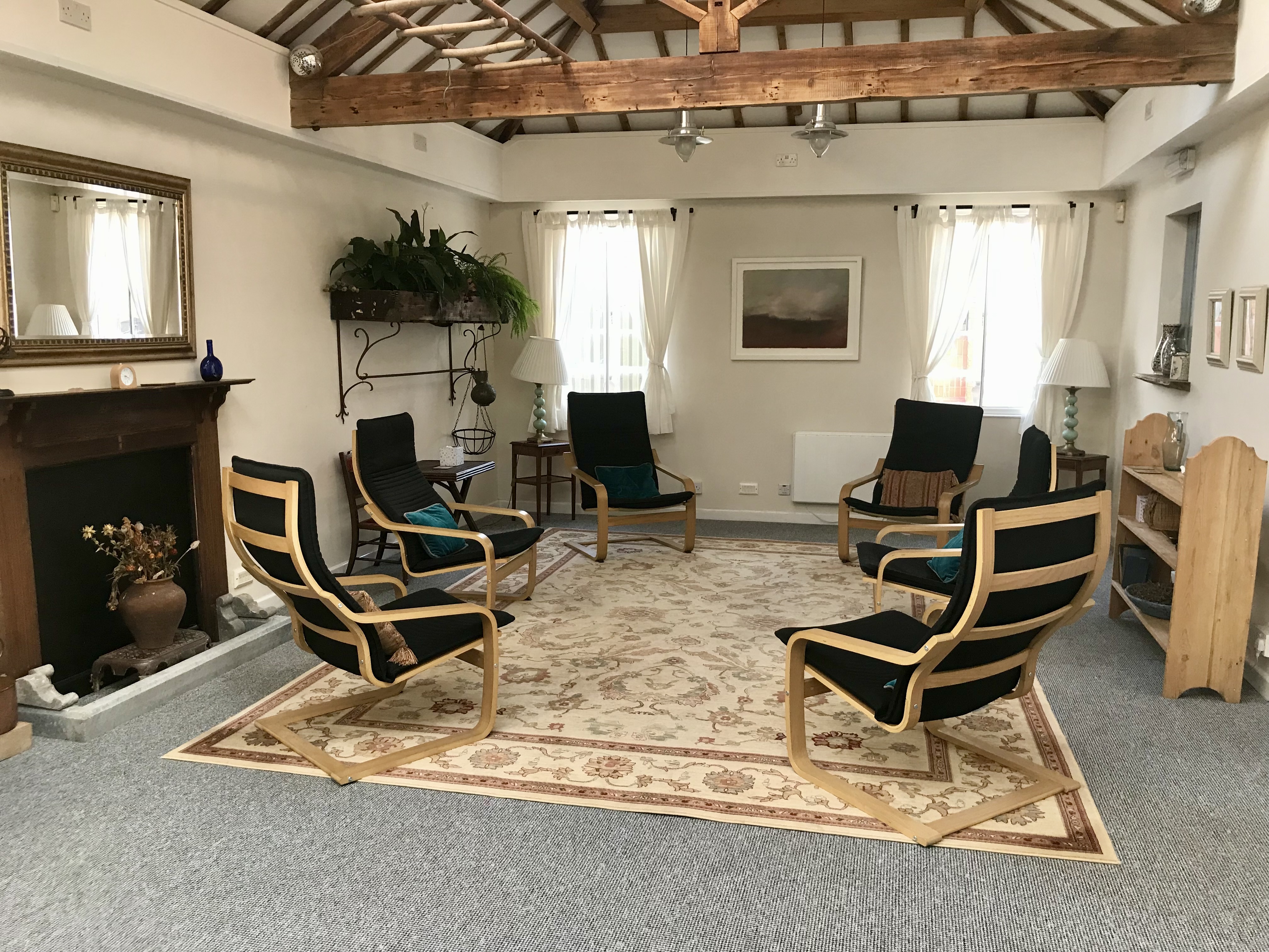 Large therapy room or group room with 6 chairs, fireplace and plants at The Practice Rooms in Stokes Croft, Bristol
