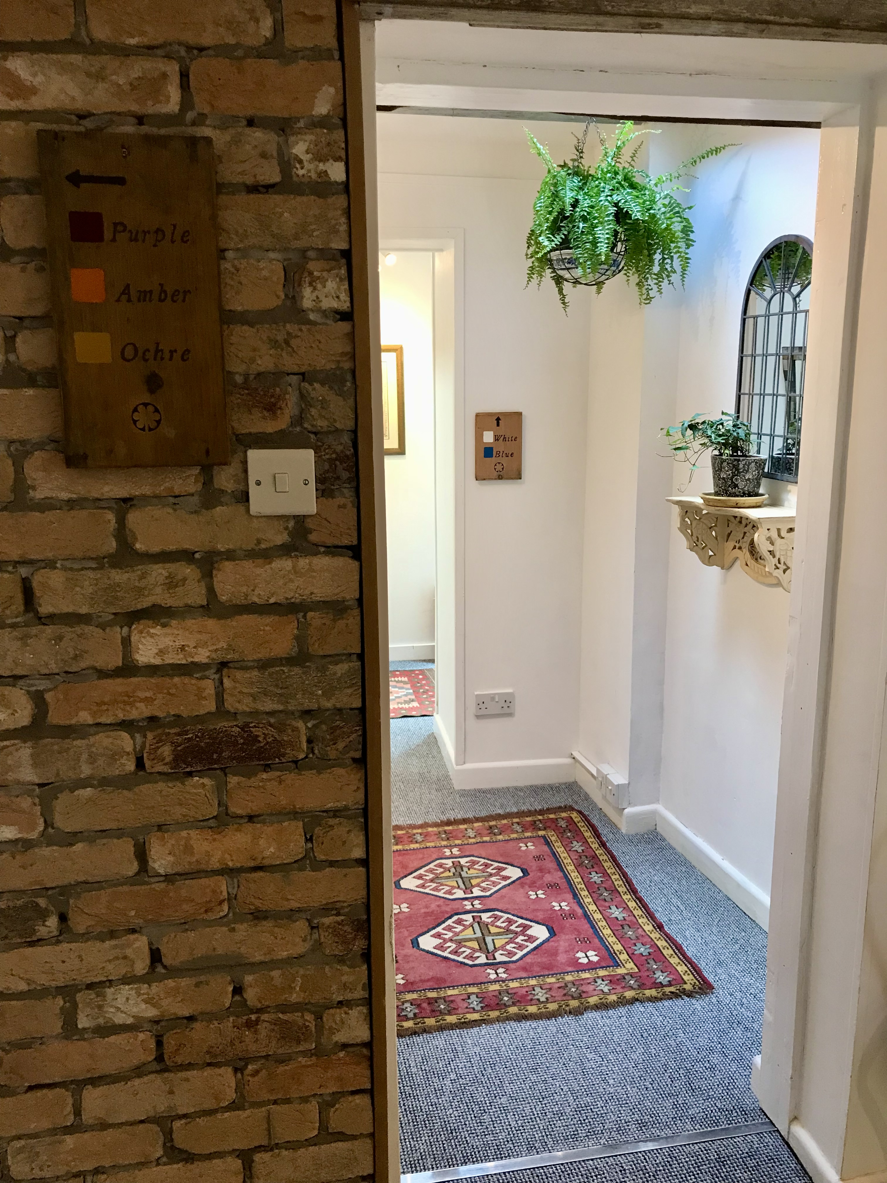 Hallway with exposed brickwork and hanging plants