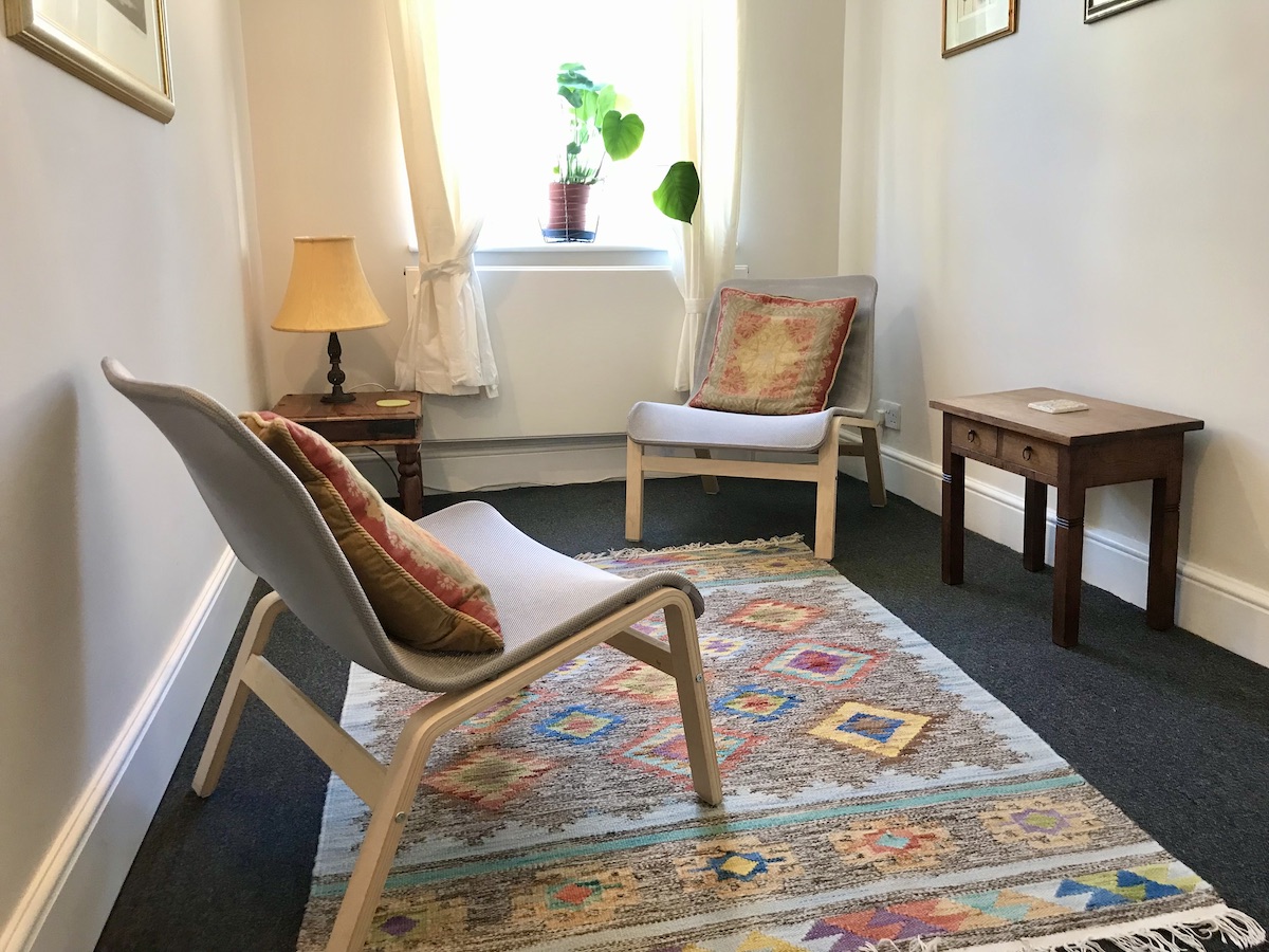Small, light therapy room with a colourful rug at The Practice Rooms in Richmond