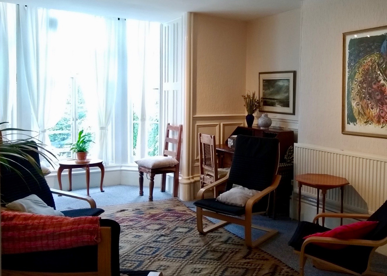 Large window in a therapy room with chairs and diamond patterned rug at The Practice Rooms in Sheffield