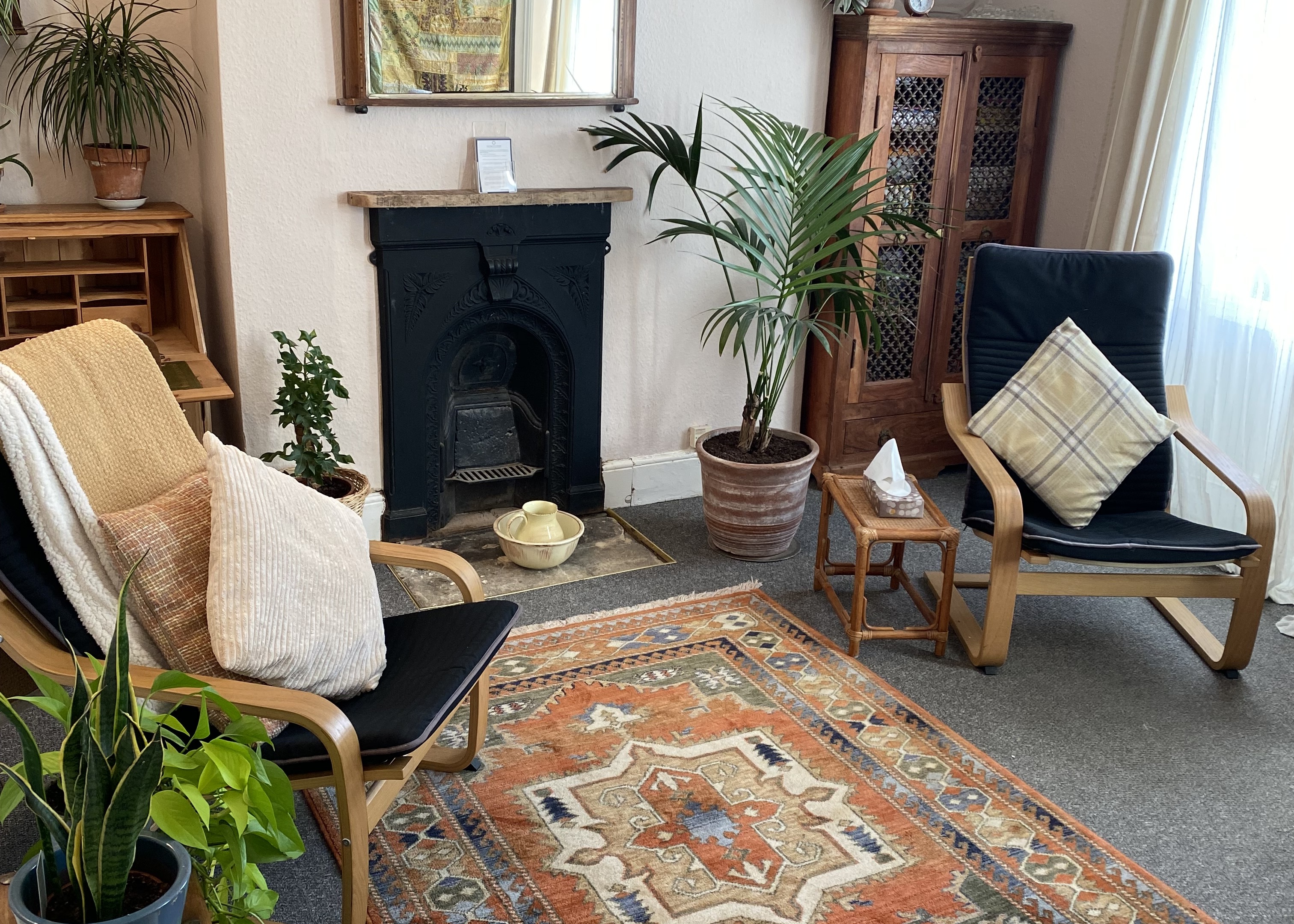 Therapy room with two chairs, fireplace and plants in The Practice Rooms in Cheltenham