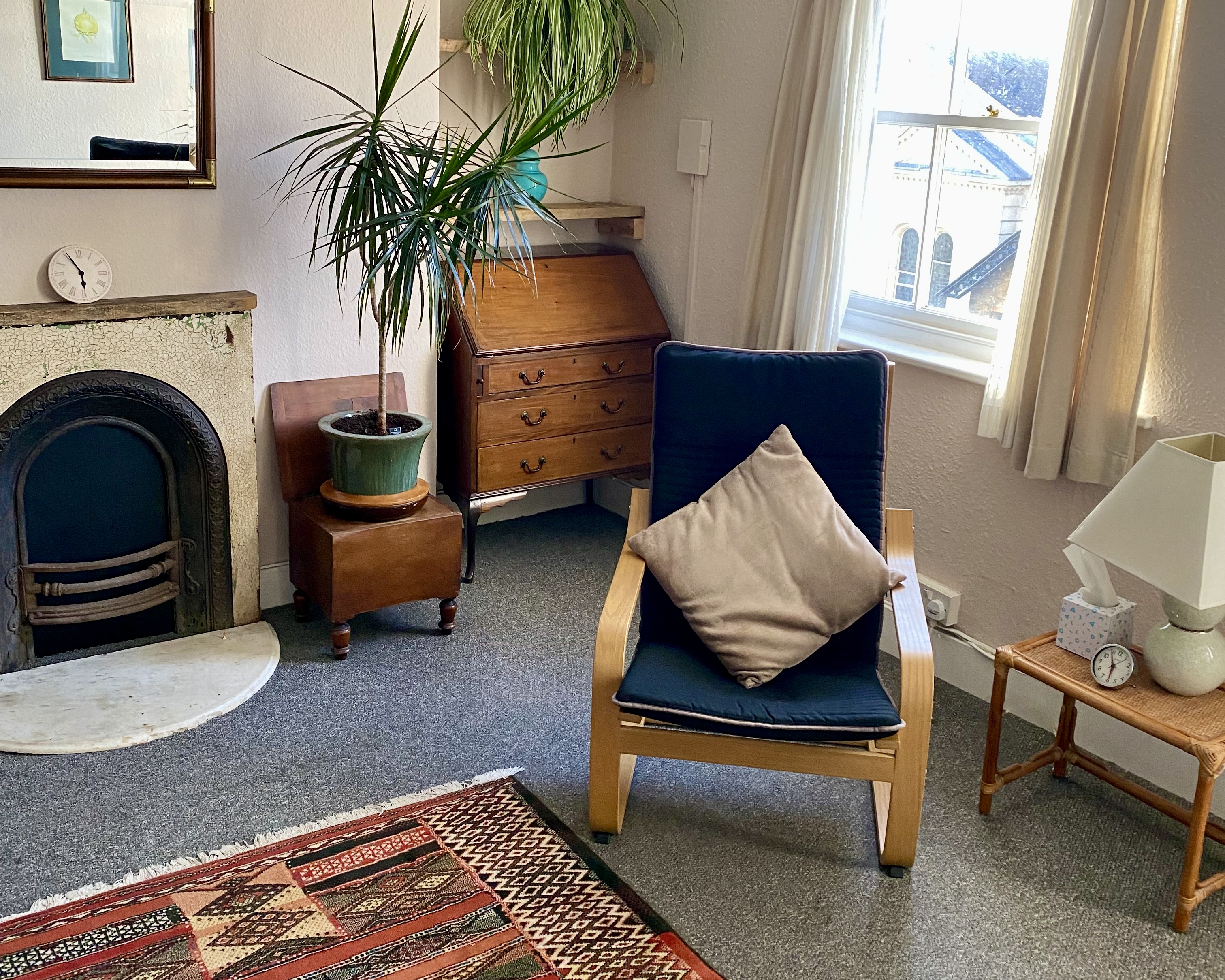 Chair, bureau and fireplace in a therapy room at The Practice Rooms in Cheltenham