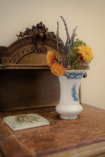 A vase of dried hours on a wooden unit